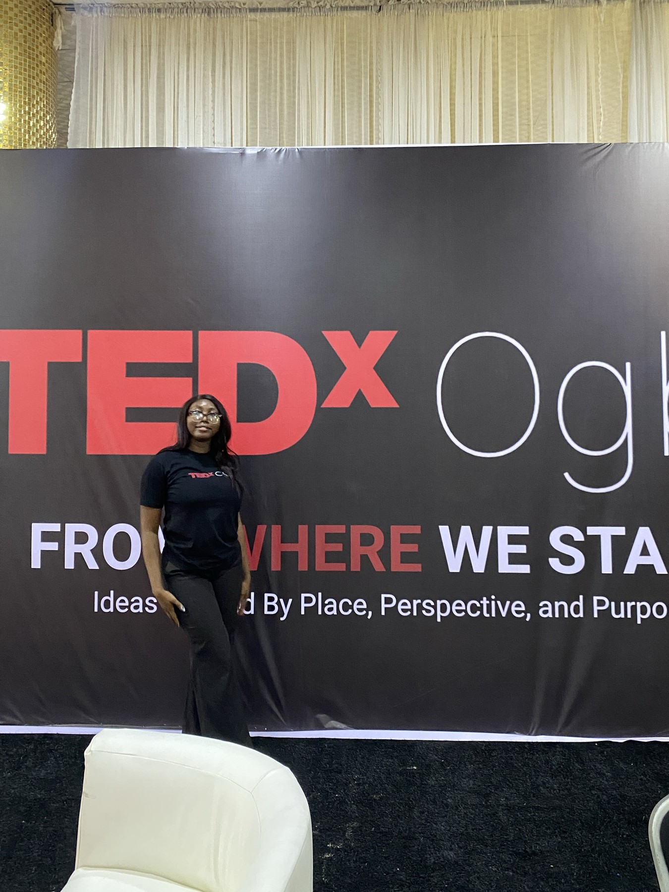 Vanessa in front of the TEDxOgba “From Where We Stand” stage banner